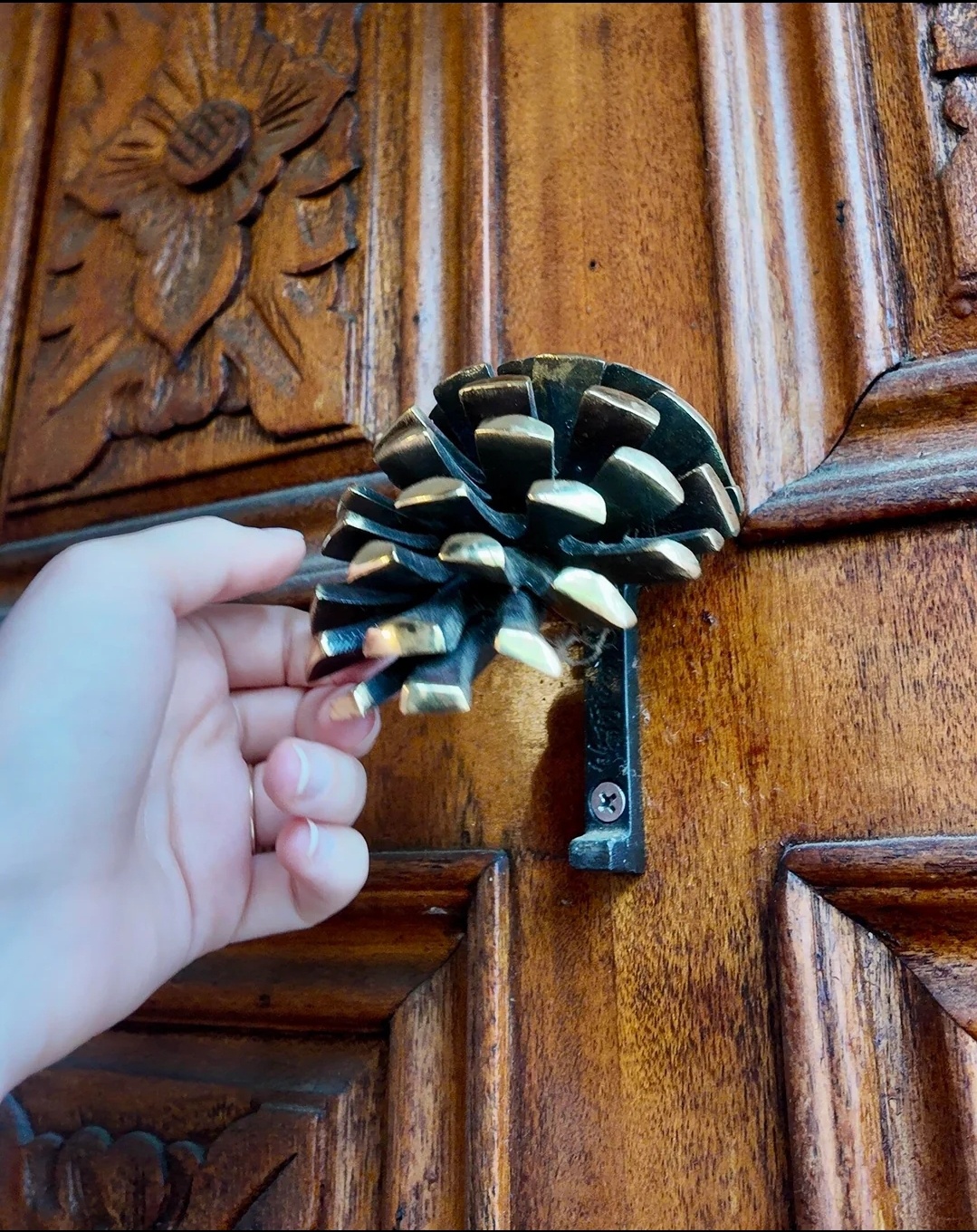 A charming pinecone door knocker to greet guests!
