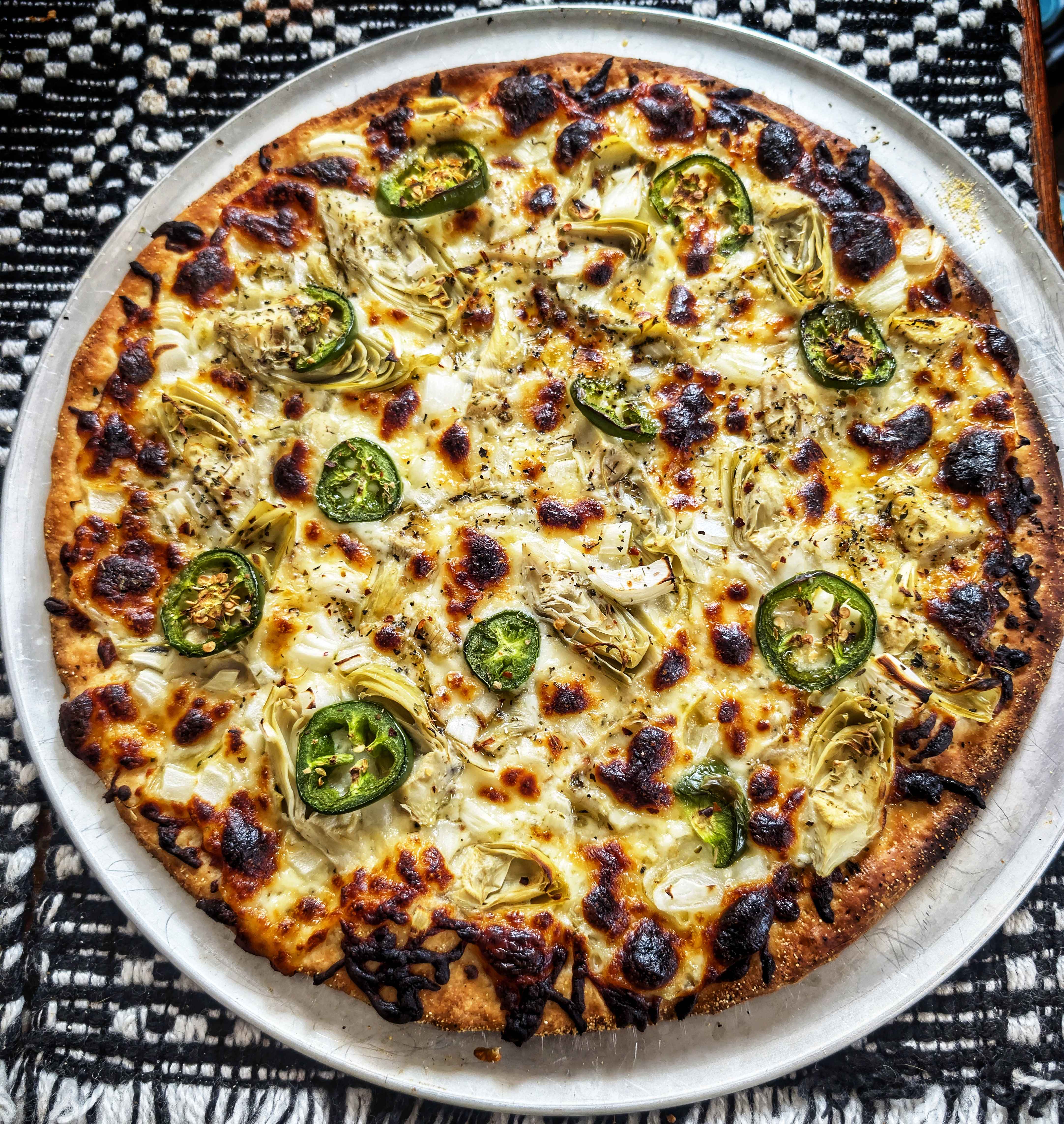 Indulge in a delicious artichoke, onion, and jalapeño pizza bianca!