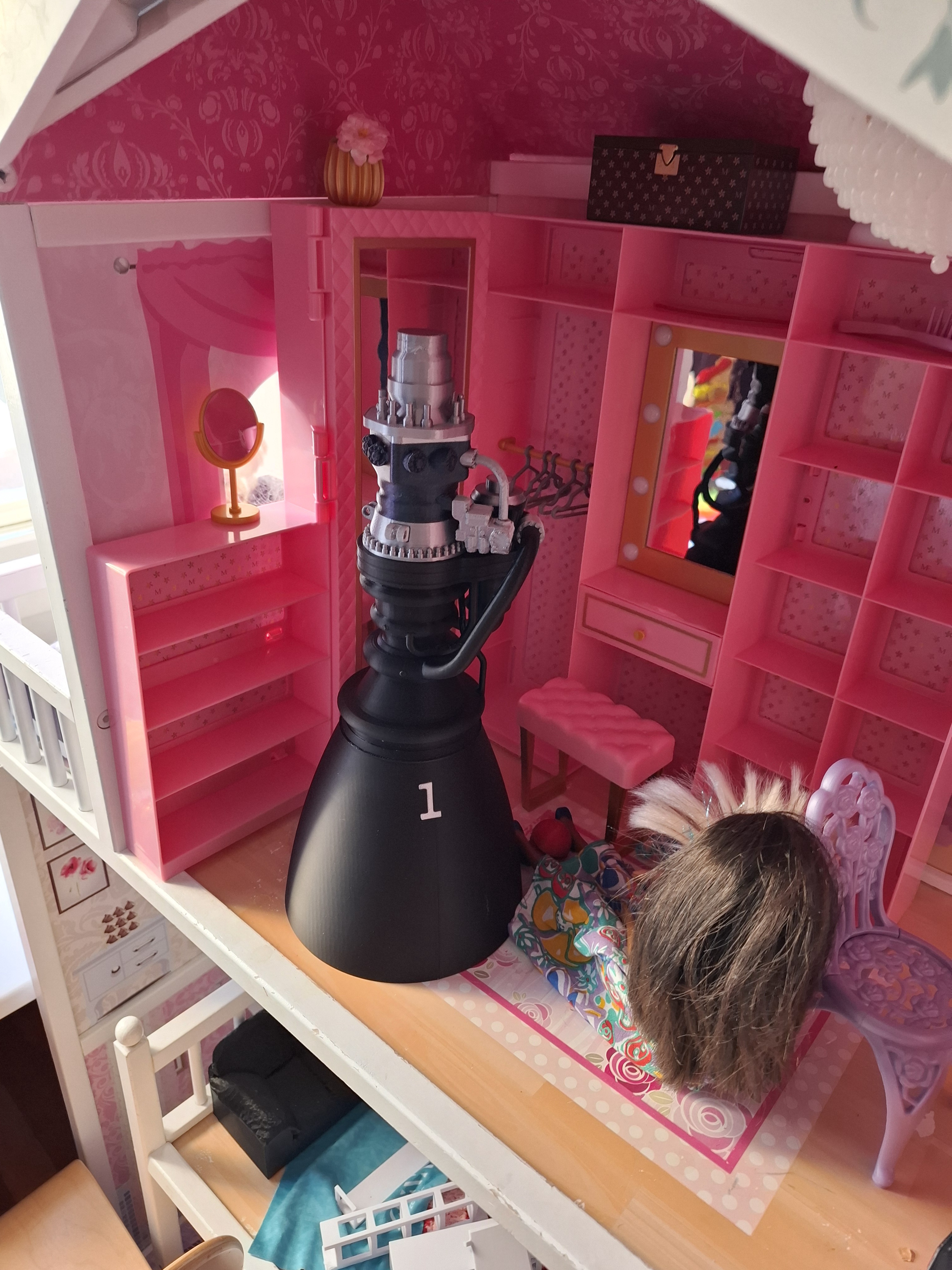 A 3D-printed Raptor 3 rocket engine nestled in a Barbie house