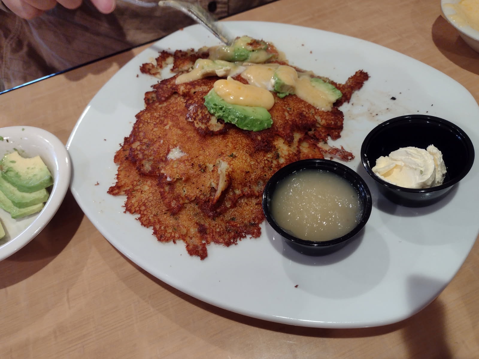 Indulging in Perkin's Potato Pancakes Topped with Avocado and Hollandaise