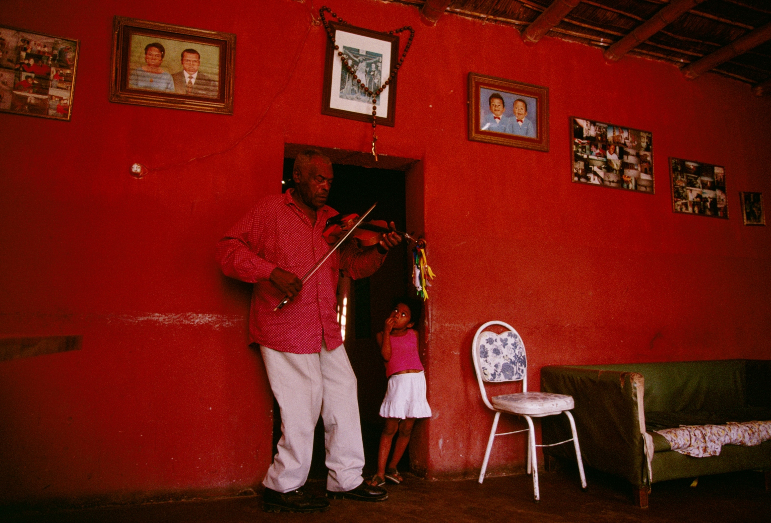 A Heartwarming Moment: Man Fiddles for His Granddaughter in El Carmen, Peru