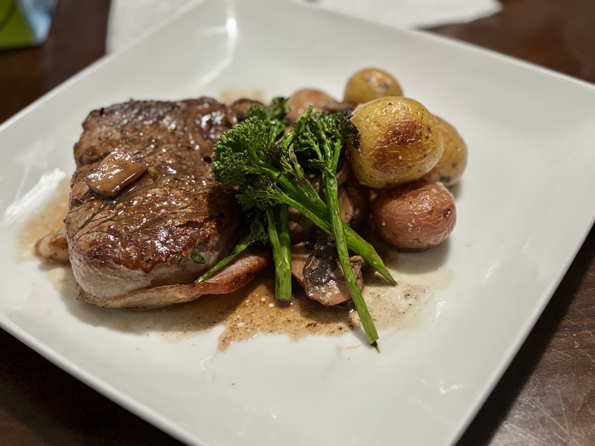 Indulge in this mouthwatering bacon-wrapped filet, paired with charred broccolini from the garden and roasted potatoes drizzled with a savory mushroom pan sauce.