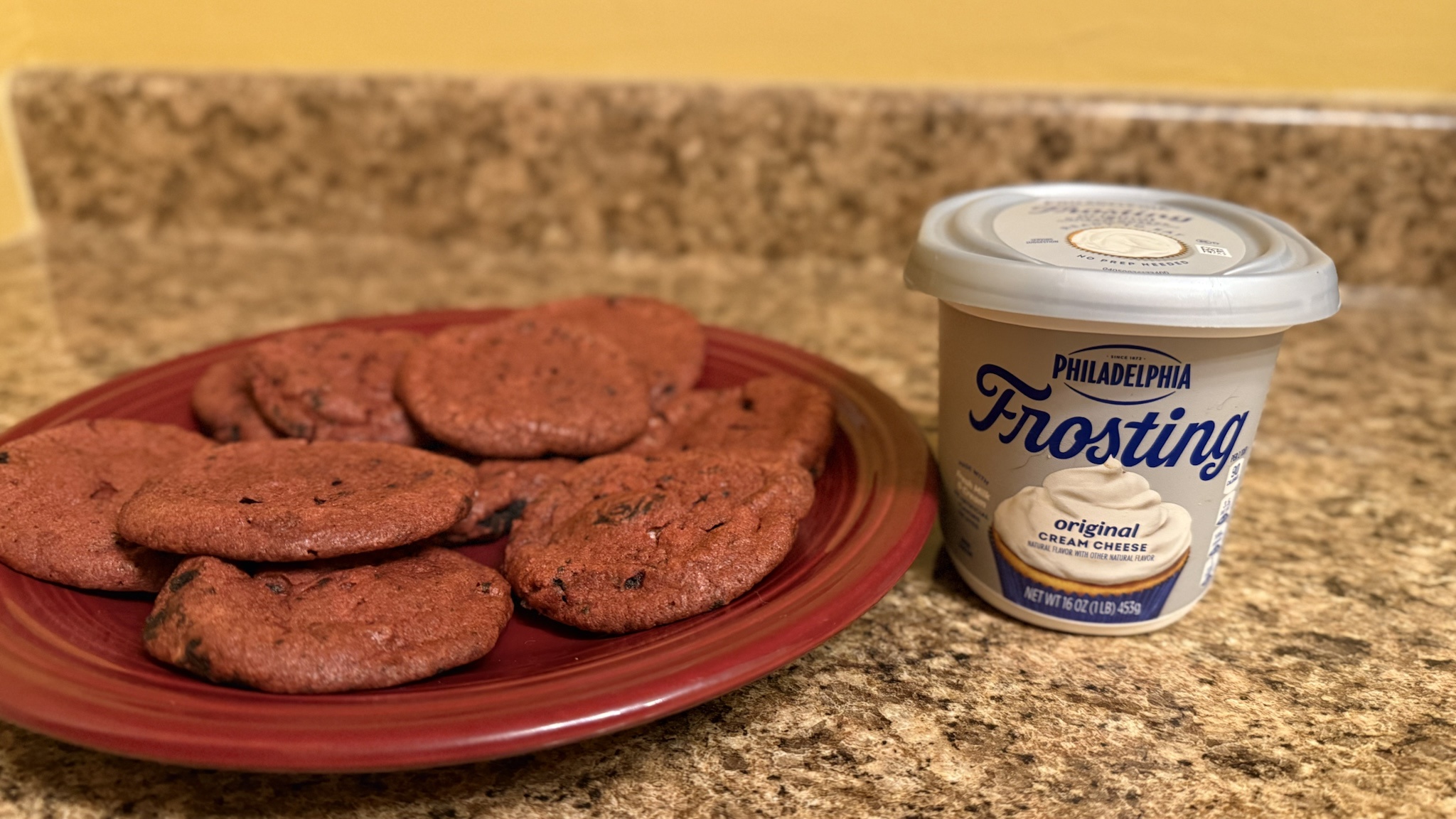 Indulge in Red Velvet Oreo Chocolate Chip Cookies topped with creamy frosting!