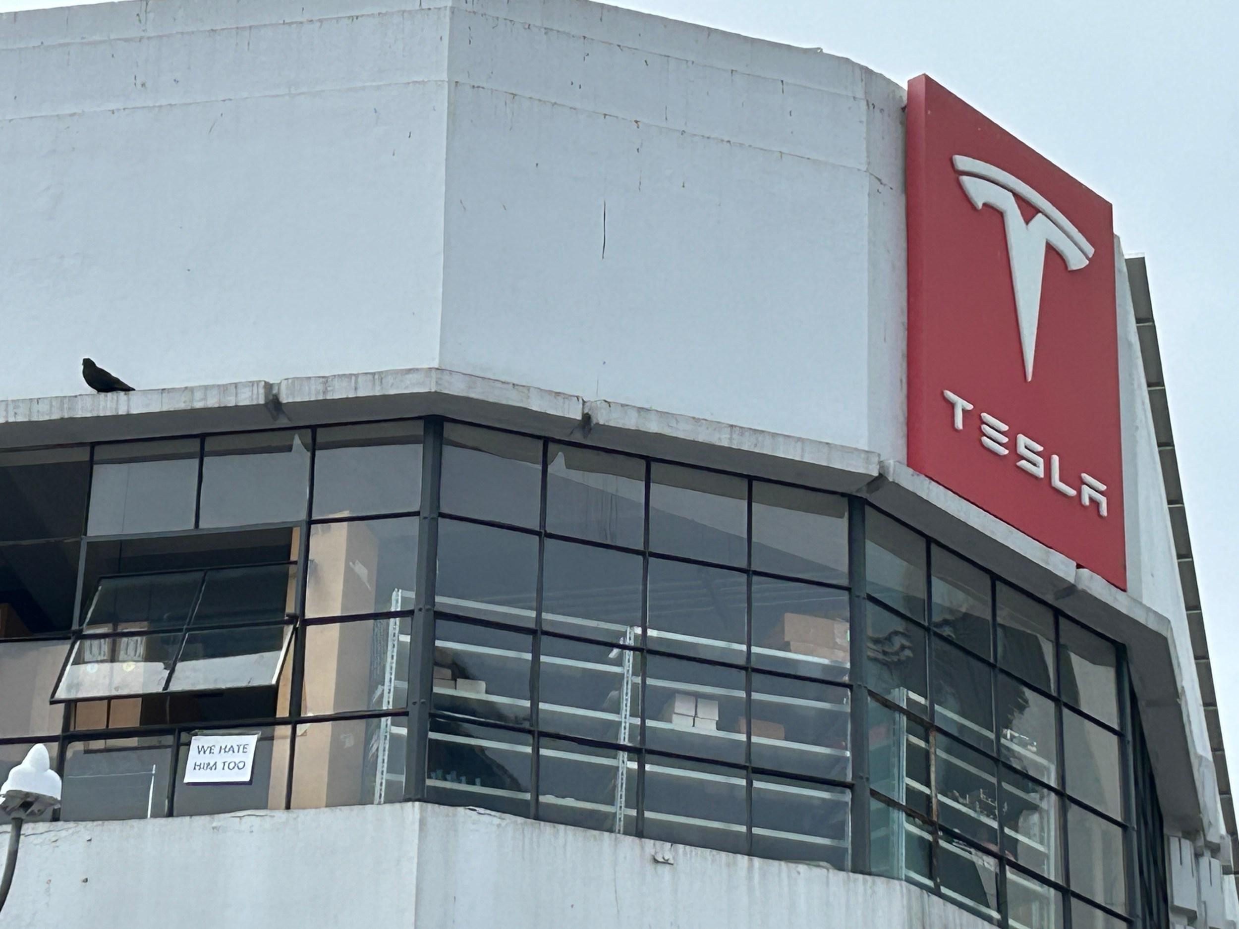 Sign spotted at a Tesla dealership: 'We’re not fans either!'