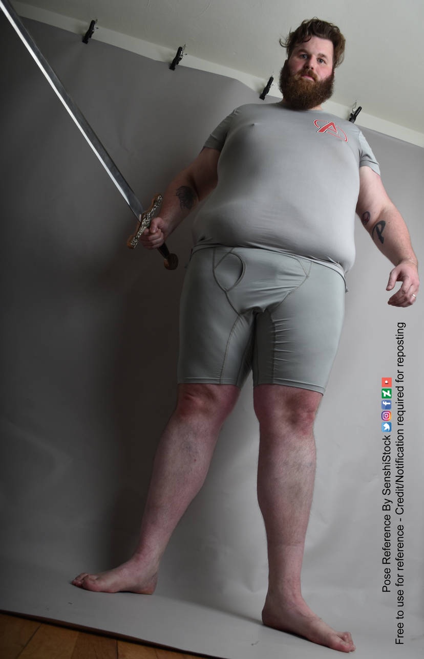 A Striking Low Angle Shot of Klaus Wielding His Sword Beneath a Towering Giant