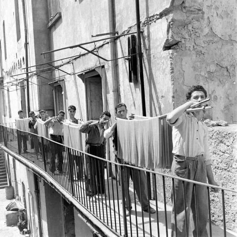 A Glimpse into 1947 Italy: Young Men Drying Pasta