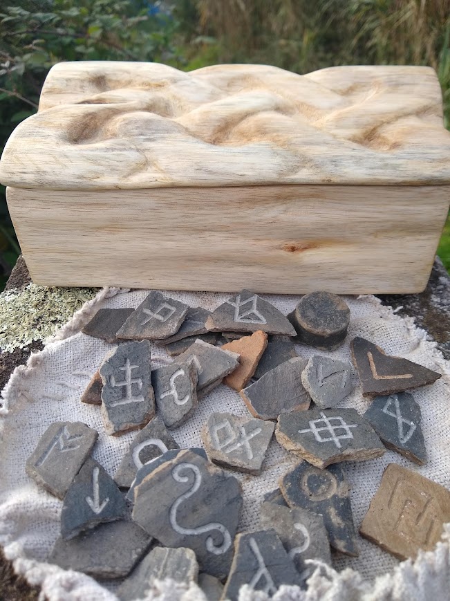 A one-of-a-kind hand-carved wooden box featuring Roman pottery designs etched into rune stones.
