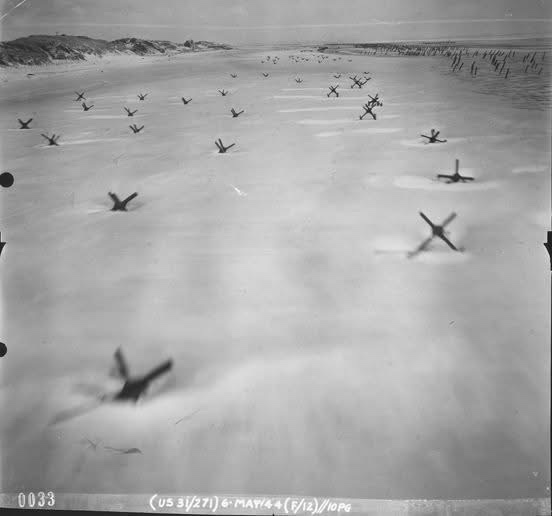 Incredible clarity captured by Lt. Albert Lanker in his F-5, showcasing the iconic hedgehog defenses on the beach.