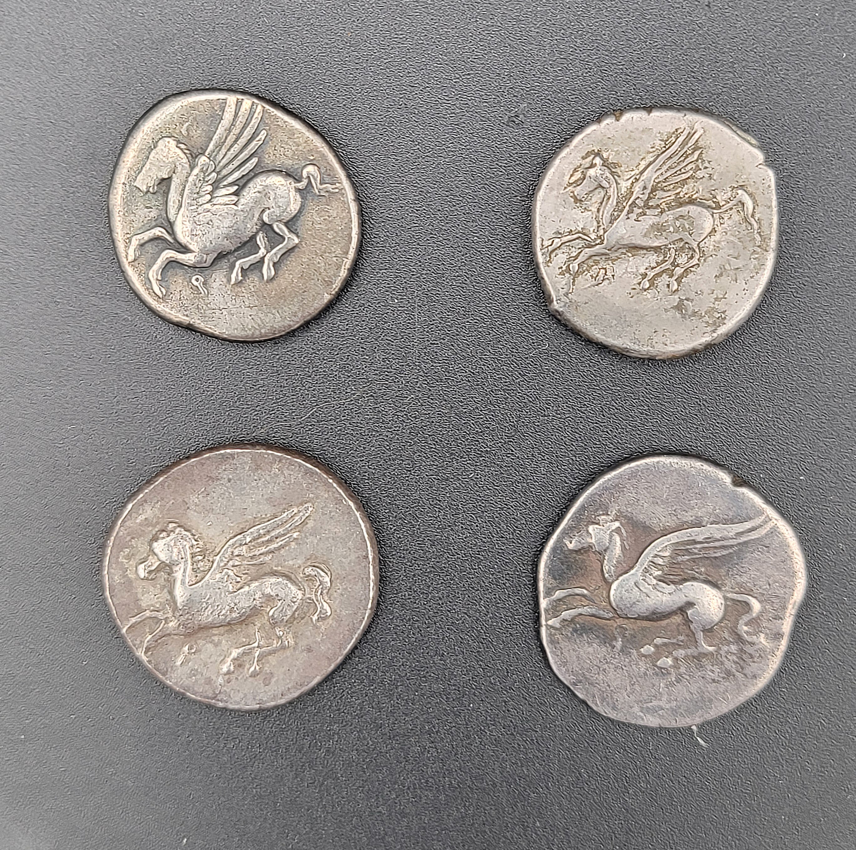 A stunning collection of four Corinth Staters from 450-300 BC, each with unique designs. Renowned for their consistent weight and beauty, these coins were widely accepted for centuries.