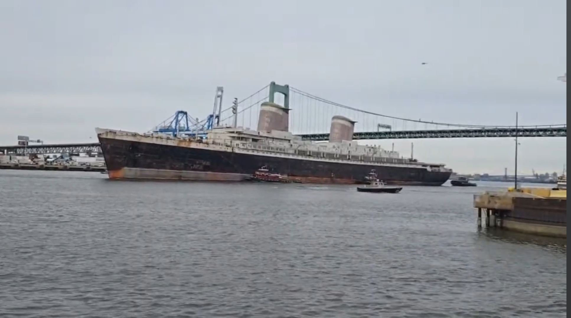 The majestic SS United States makes its way under the Walt Whitman Bridge, headed for Alabama.