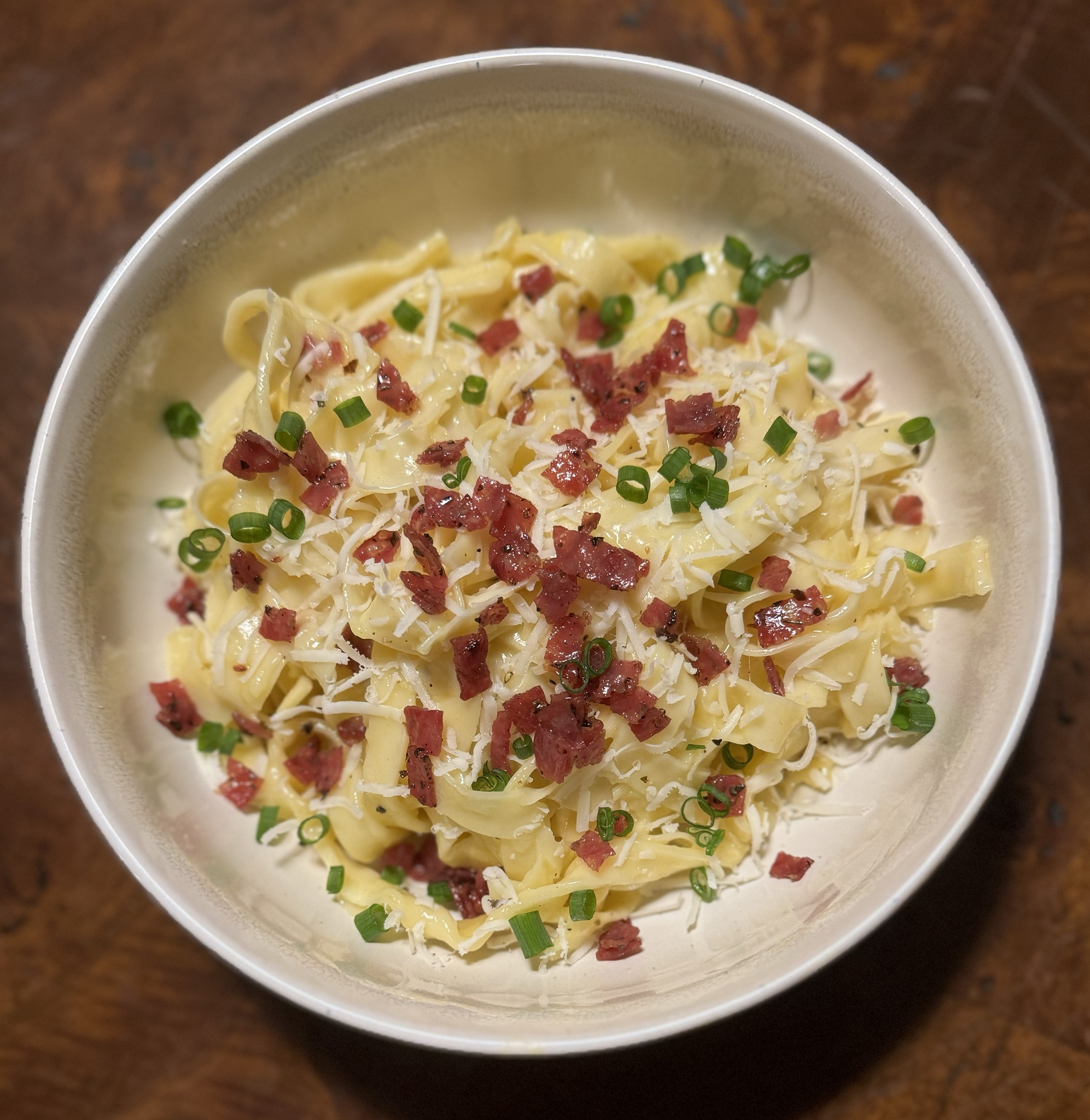 Indulge in carbonara with fresh pasta, crispy salami, creamy Auribella cheese, and scallions.