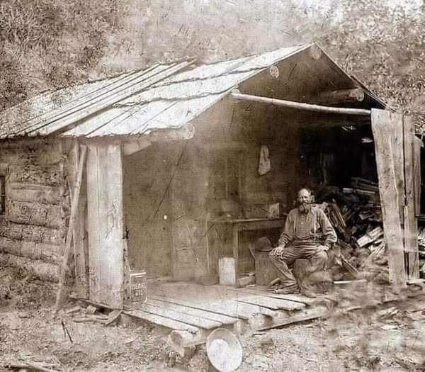 In the summer of 1889, a man enjoys the tranquility on his weathered porch in Eagle Creek, Murray, Idaho.