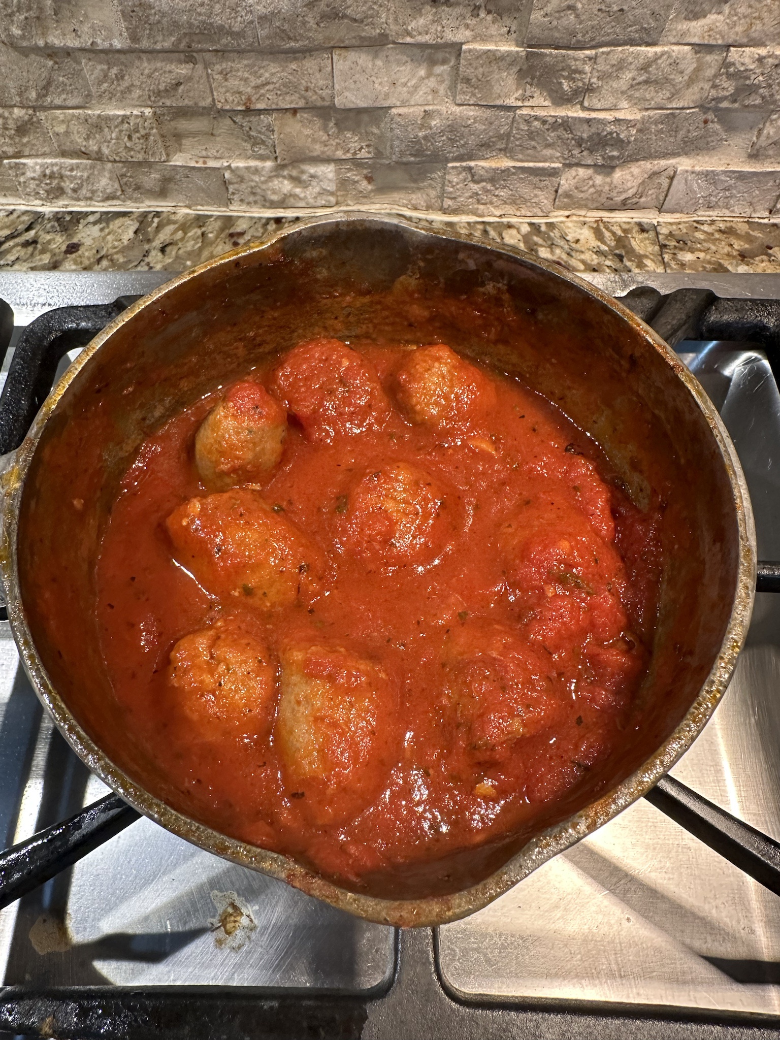 Savoring Italian sausage and meatballs in rich red sauce.