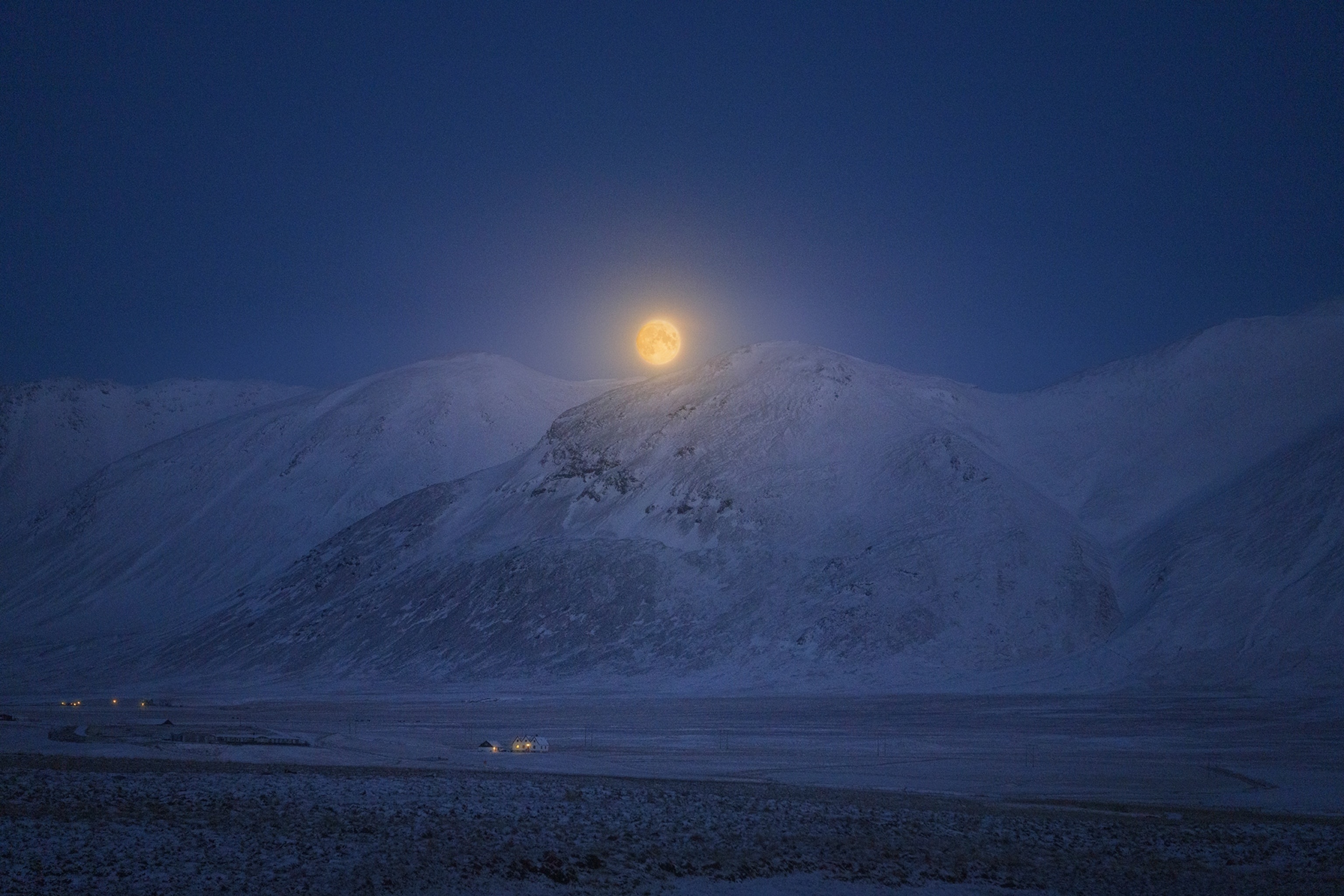 A Stunning Full Moon Rises Over Iceland's Snowy Peaks