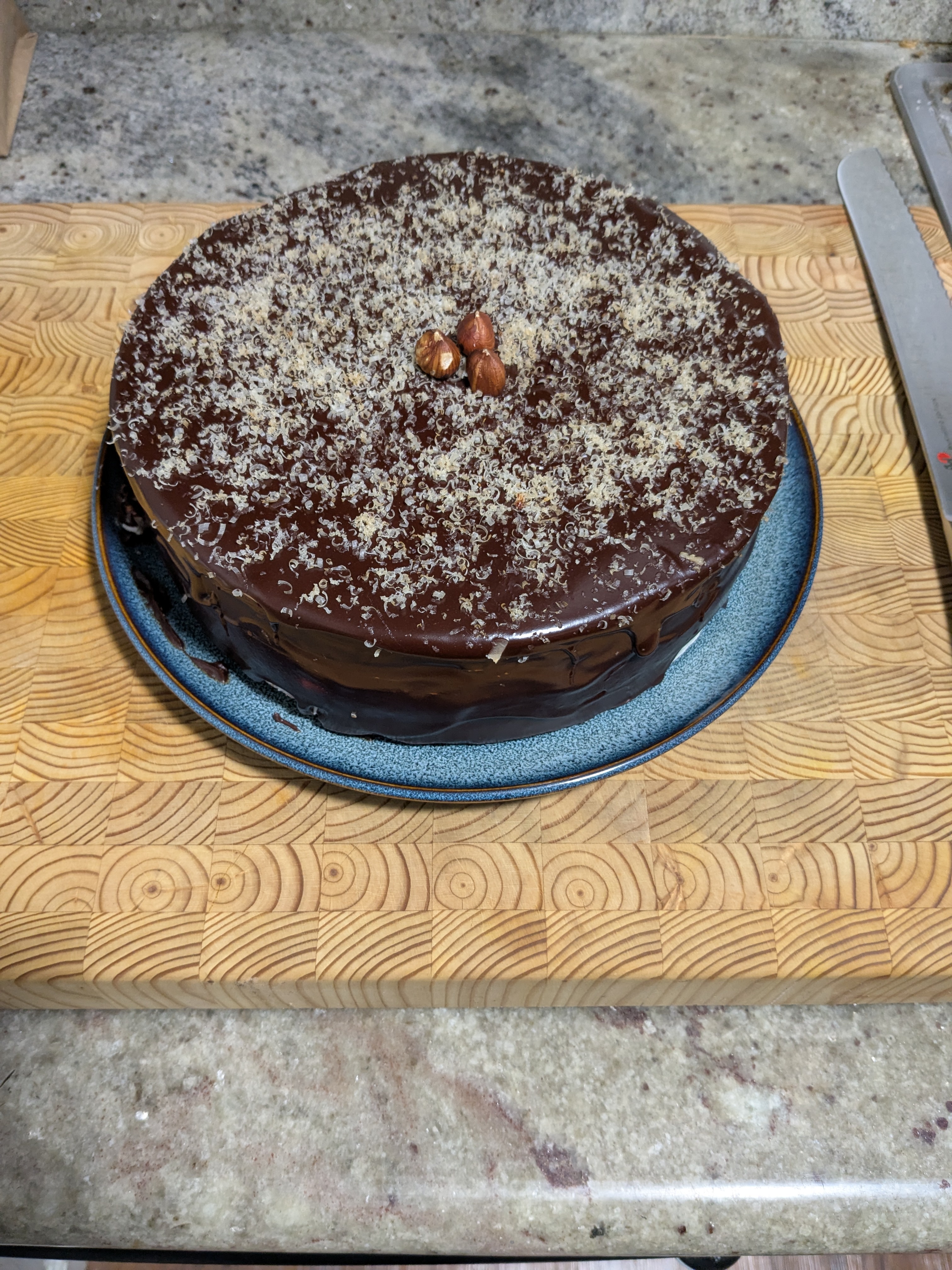 Indulge in This Dark Chocolate Glazed Butter Cake with Vanilla Swiss Meringue Buttercream and Hazelnut Shavings