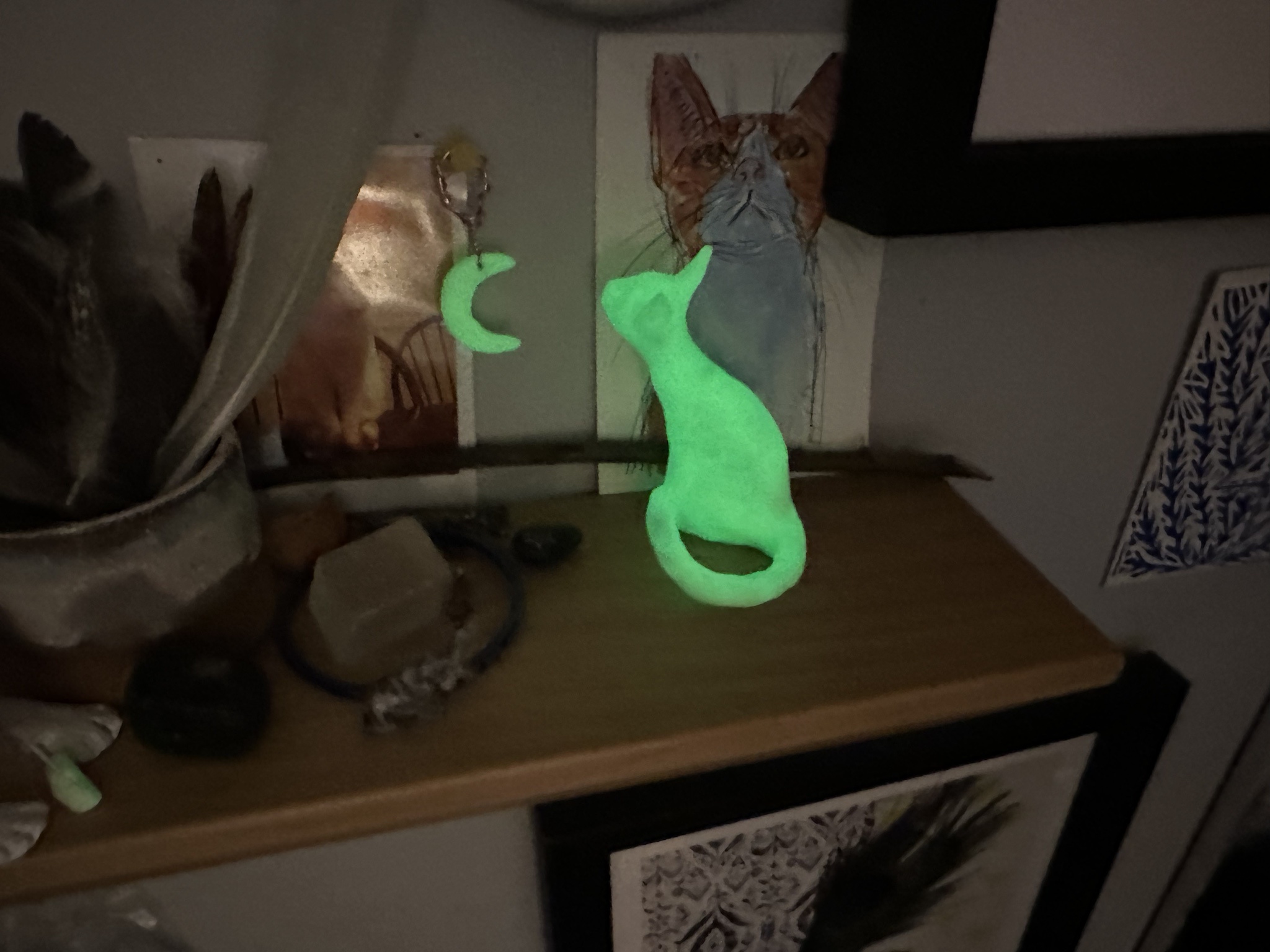 Adorable miniature cat sculpture adorned with a glowing moon pendant