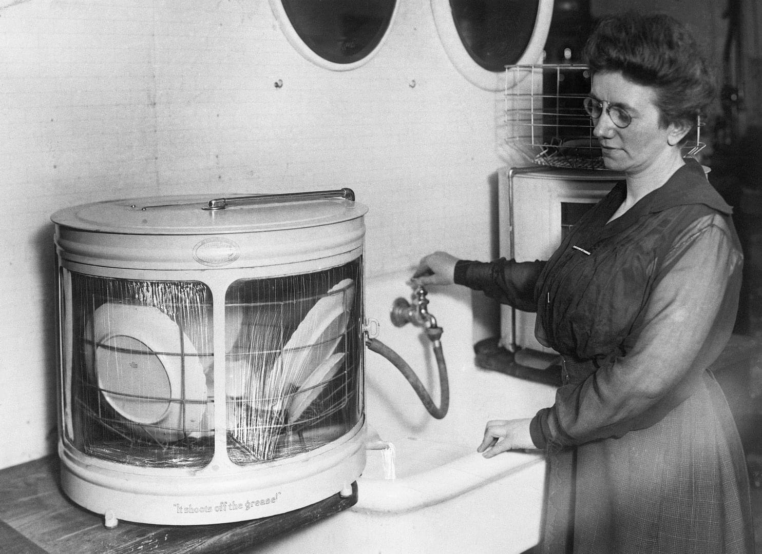 A Woman Showcasing an Early 1920s Dishwashing Machine