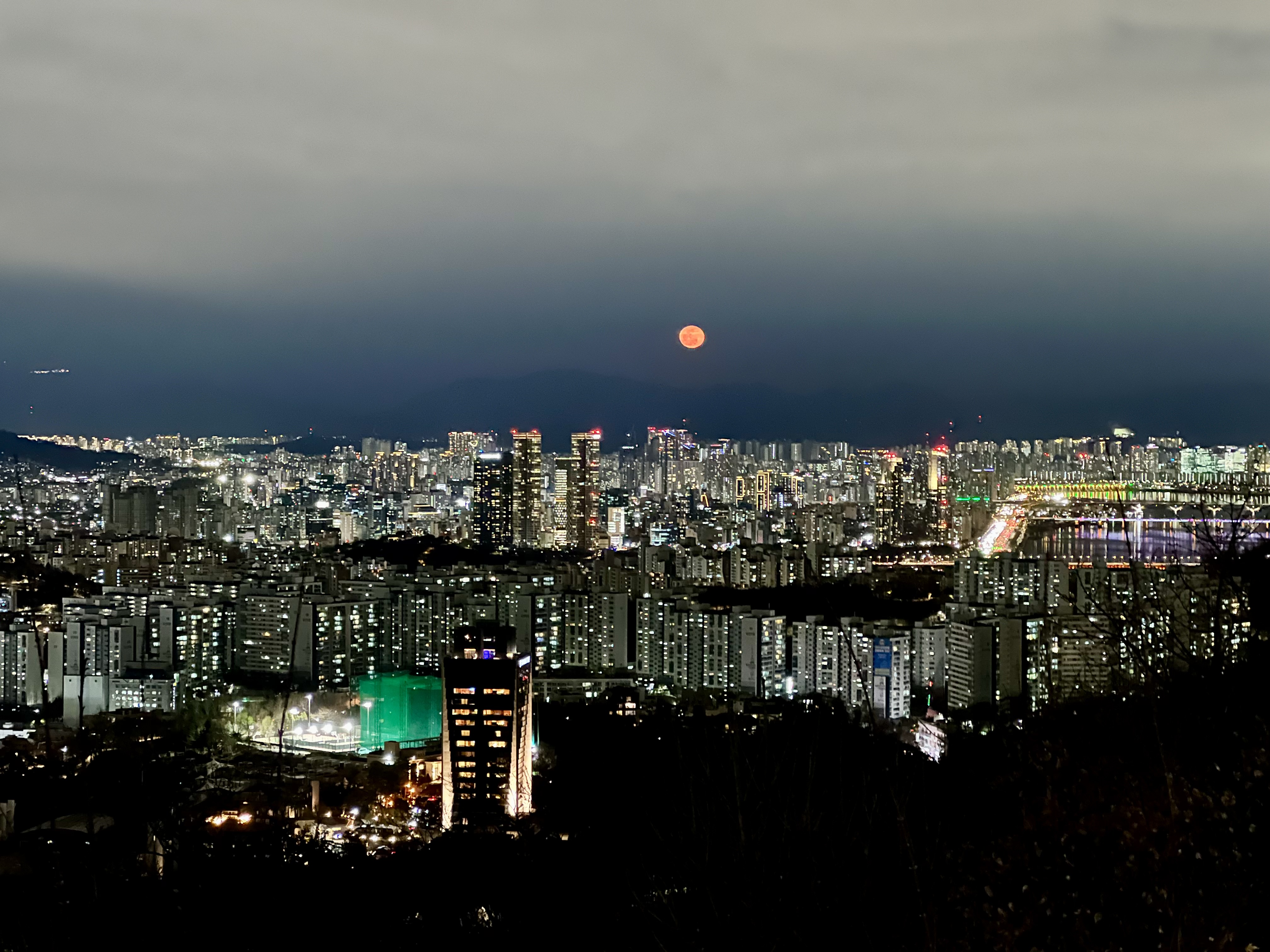 A breathtaking full moon casts its glow over the skyline of Seoul