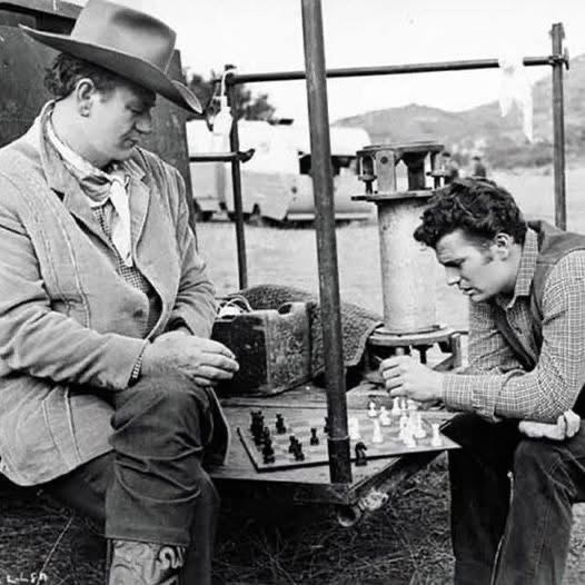 John Wayne and his son Patrick enjoying a chess match during a break on the set of 'McLintock!'