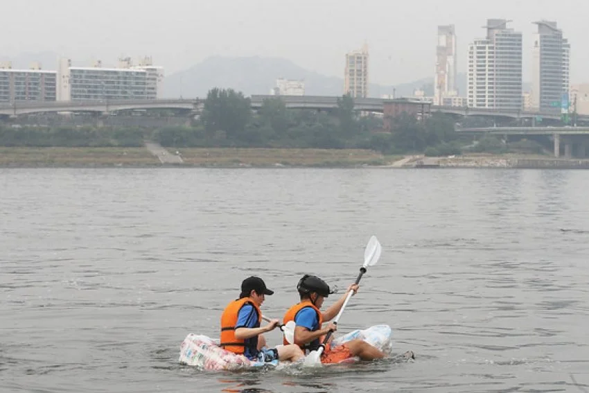 Two Korean students create a raft using over 100 unopened chip bags to protest and demonstrate how much air is wasted in packaging.